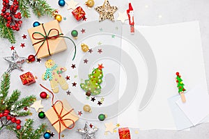 Christmas background with gift boxes, festive decor, fir tree branches and paper cards notes. Flat lay