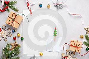 Christmas background with gift boxes, festive decor, fir tree branches and paper cards notes. Flat lay