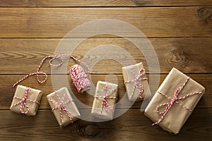 Christmas background. Gift boxes wraped in craft paper over wooden background. Top view, rustic style. Copy space