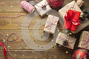 Christmas background with gift boxes wraped in craft paper over wooden table prepared for celebrating festive holiday season. Copy
