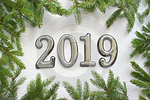 Christmas background with gift, Christmas tree and numbers 2019 on white wooden table.