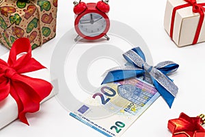 Christmas background with gifts, alarm clock and 20 euros. The concept of preparation for winter holidays. It`s time to buy gifts