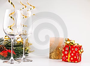 Christmas background glasses of wine on the background of a spruce branch, candles and mandarin decorations