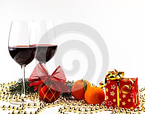 Christmas background glasses of wine on the background of a spruce branch, candles and mandarin decorations