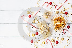 Christmas background of golden confetti, gift or present boxes and holiday decorations top view. Flat lay.