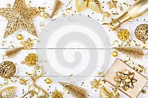 Christmas background with golden gift or present box, champagne and holiday decorations top view. Greeting card. Flat lay