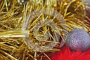 Christmas background of golden tinsel and Christmas silver ball on red fur.