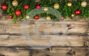 Christmas background with green branches and christmas balls on the rustic wooden background