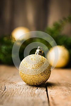 Christmas background with green branches and christmas balls on the rustic wooden background