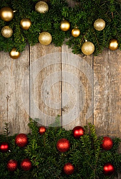 Christmas background with green branches and christmas balls on the rustic wooden background. Flat lay.