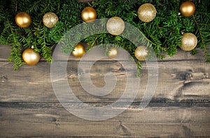 Christmas background with green branches and christmas balls on the rustic wooden background. Flat lay.