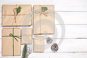 Christmas background with handmade present gift boxes and rustic decoration on white wooden board.