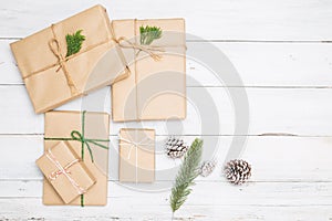 Christmas background with handmade present gift boxes and rustic decoration on white wooden board