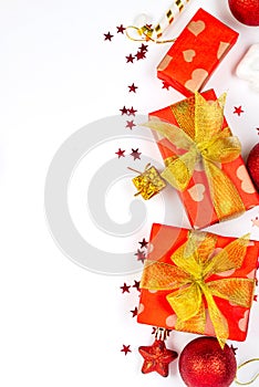 Christmas background. Holidays gift box wrapped in red paper, red and gold christmas baubles on white background