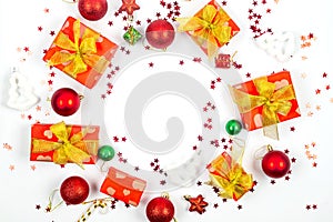 Christmas background. Holidays gift box wrapped in red paper, red and gold christmas baubles on white background