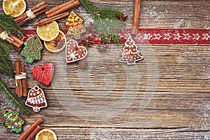 Christmas background. Homemade gingerbread cookies, cinnamon, Christmas tree on old wooden background. Toned, soft focus, copy spa