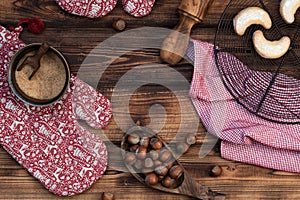 Christmas background. Homemade vanilla candy on a chilling grid, red Christmas mittens and kitchen towel on a wooden background.