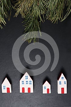 Christmas background - houses and fir tre branches isolated against black background flat lay