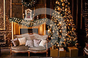 Christmas background with illuminated fir tree with golden decpration and fireplace in living room. Cozy holiday home