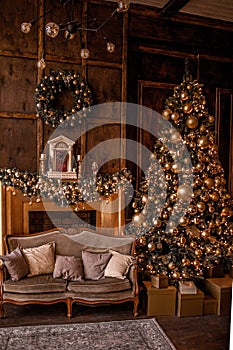 Christmas background with illuminated fir tree with golden decpration and fireplace in living room. Cozy holiday home