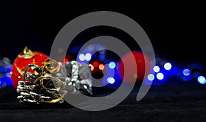 Christmas background image, red balls on the blurred background, blue lights, focus on the pine cone