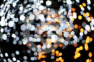 Christmas background with lights. Holiday light bulbs. Cosmic background. red, gold and black glitter lights. defocused