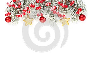 Christmas background made with evergreen tree branches, red holly berries, gold and red baubles isolated on white background.