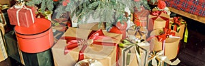 Christmas background with many gift boxes decorated with ribbon on floor under Christmas tree. Winter holidays concept