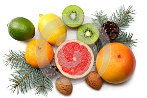 Christmas background. mix sliced lemon, green lime, orange, mandarin, kiwi fruit and grapefruit with cone and fir tree isolated