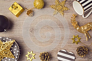 Christmas background with modern black and golden decorations on wooden table. View from above