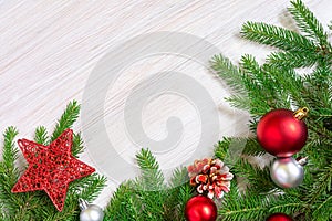 Christmas background. New year frame made of fir branches and red christmas toys on white wood board. Flat lay, Copy