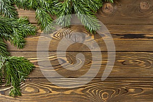 Christmas background. Nobilis fir branches, twigs on brown wooden planks. Copy space, flat lay, top view. Holiday, Xmas, New Year
