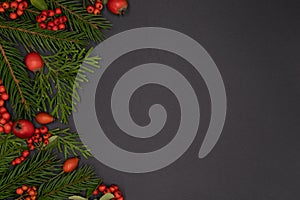 Christmas background of pine branches decorated with red toys and berries, new year concept, flat lay, top view