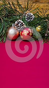 Christmas background with pine branches, pine cones and baubles.