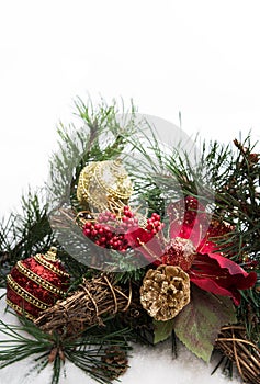 Christmas background with pine tree branch, pine cones, red flower in snow