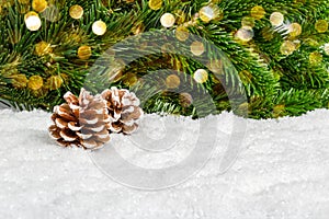 Christmas background for product presentation with pine cones in snow under fir tree. Pine branches and bokeh lights as
