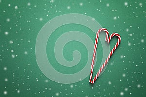 Christmas background with red candy canes in the shape of heart.