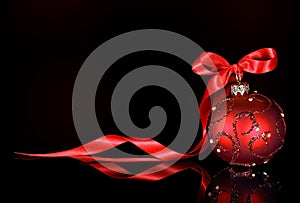 Christmas background with red ornament and ribbon on a black background