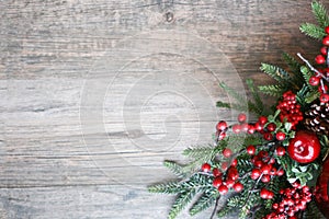 Christmas Background with Rustic Evergreen Pine Tree Branches and Red Berries Over Wood Table