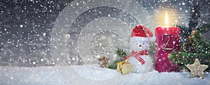 Christmas background with second Advent candle and Snowman with red decoration.