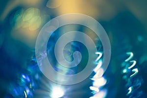 Christmas background with shining lights and flares in purple and blue. Holiday glowing backdrop. Defocused Background