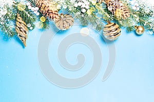 Christmas flatlay background - fir tree and golden decorations on blue.