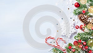Christmas background with snowy fir branches, decorations, cones and bokeh lights. Holiday banner or card