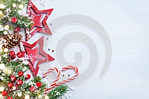 Christmas background with stars, snowy fir branches, cones and bokeh lights. Holiday banner or card