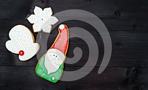 Christmas background with tasty homemade gingerbread cookies with icing on wooden table, top view, flat lay. Santa, snowflake.