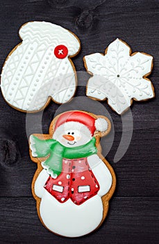 Christmas background with tasty homemade gingerbread cookies with icing on wooden table, top view, flat lay.