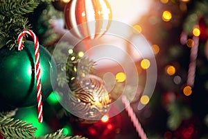 Christmas background tree branch with decorations candy lollipop cane red and green balls, with bokeh sun light