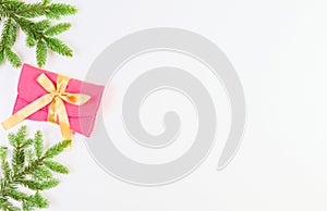 Christmas background. Christmas tree branch and present with gold ribbon on white background