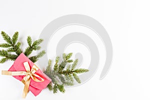 Christmas background. Christmas tree branch and present with gold ribbon on white background