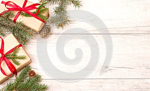 Christmas background, wallpaper. Happy New Year composition. Christmas gift with red ribbon, pine cones, fir branches on wooden